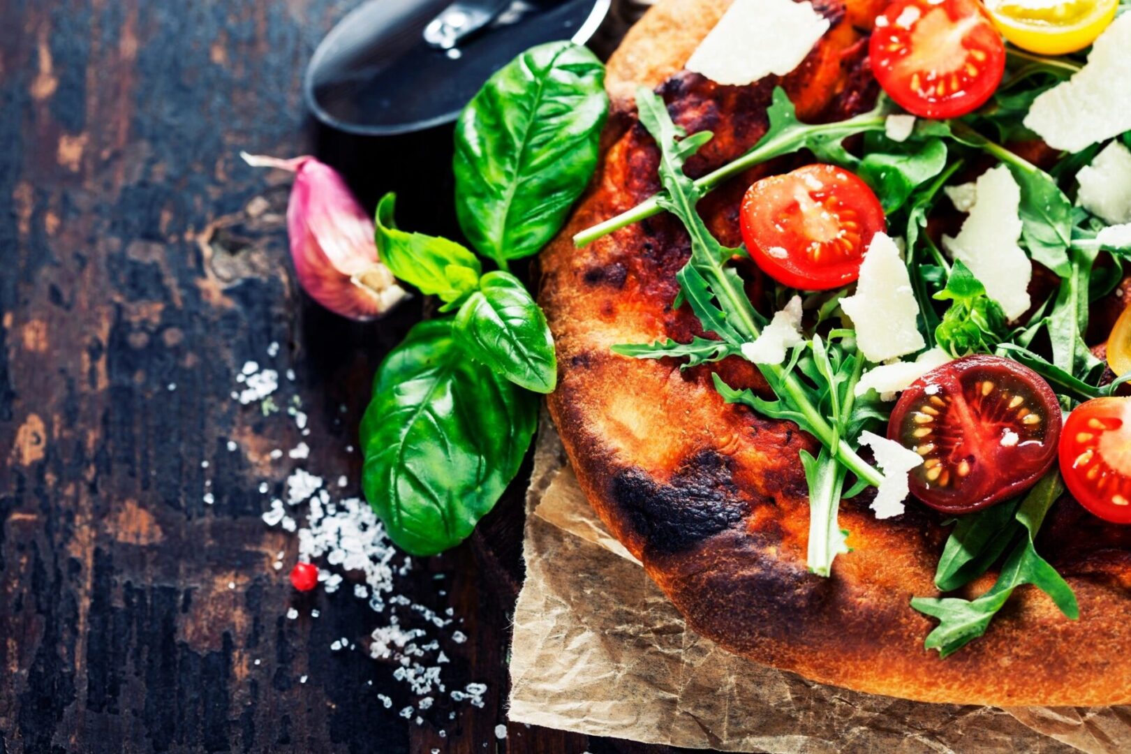 A pizza with tomato and green leaves